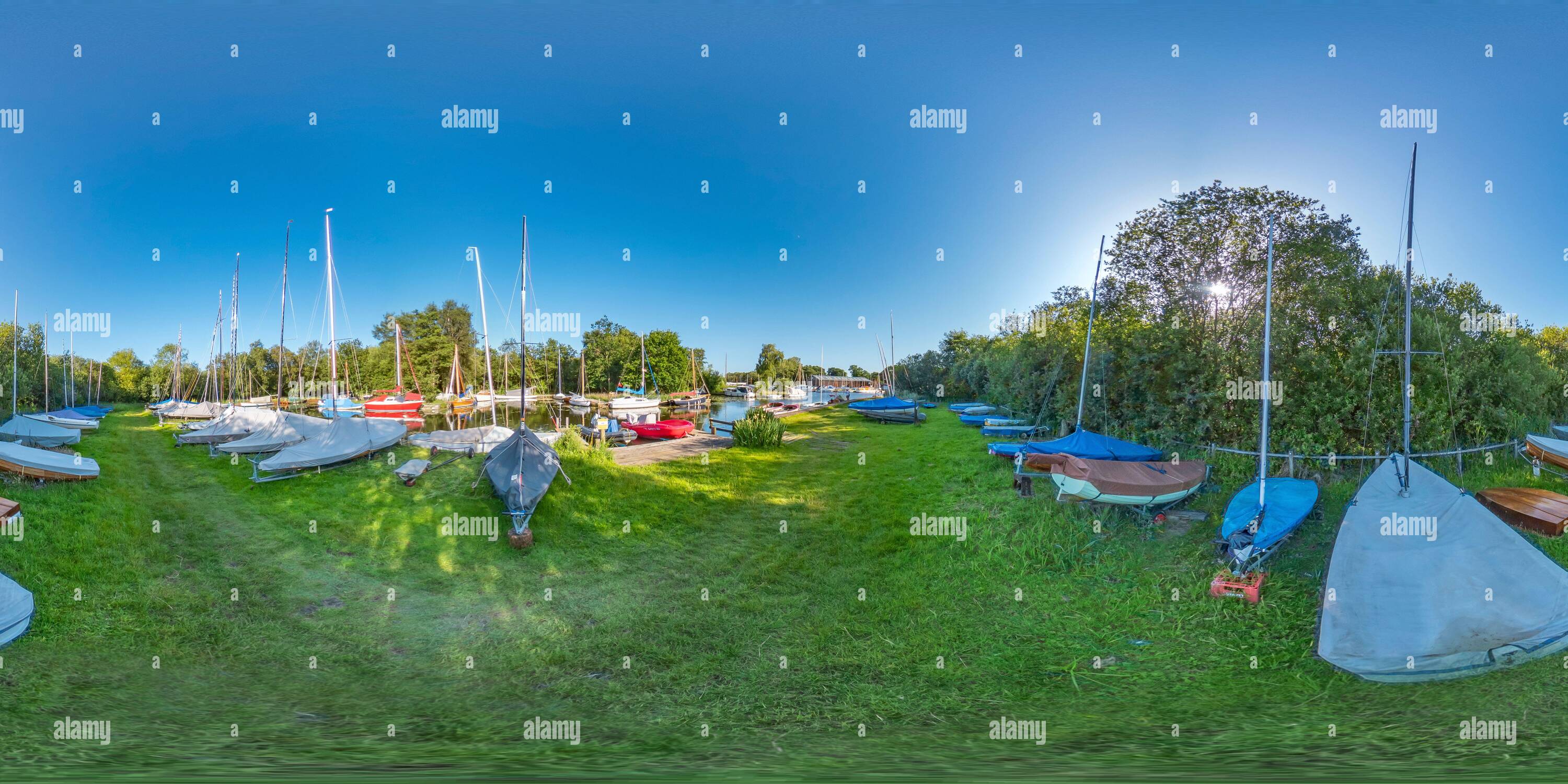 360° view of Sailing punts and boats moored in grass field beside the ...