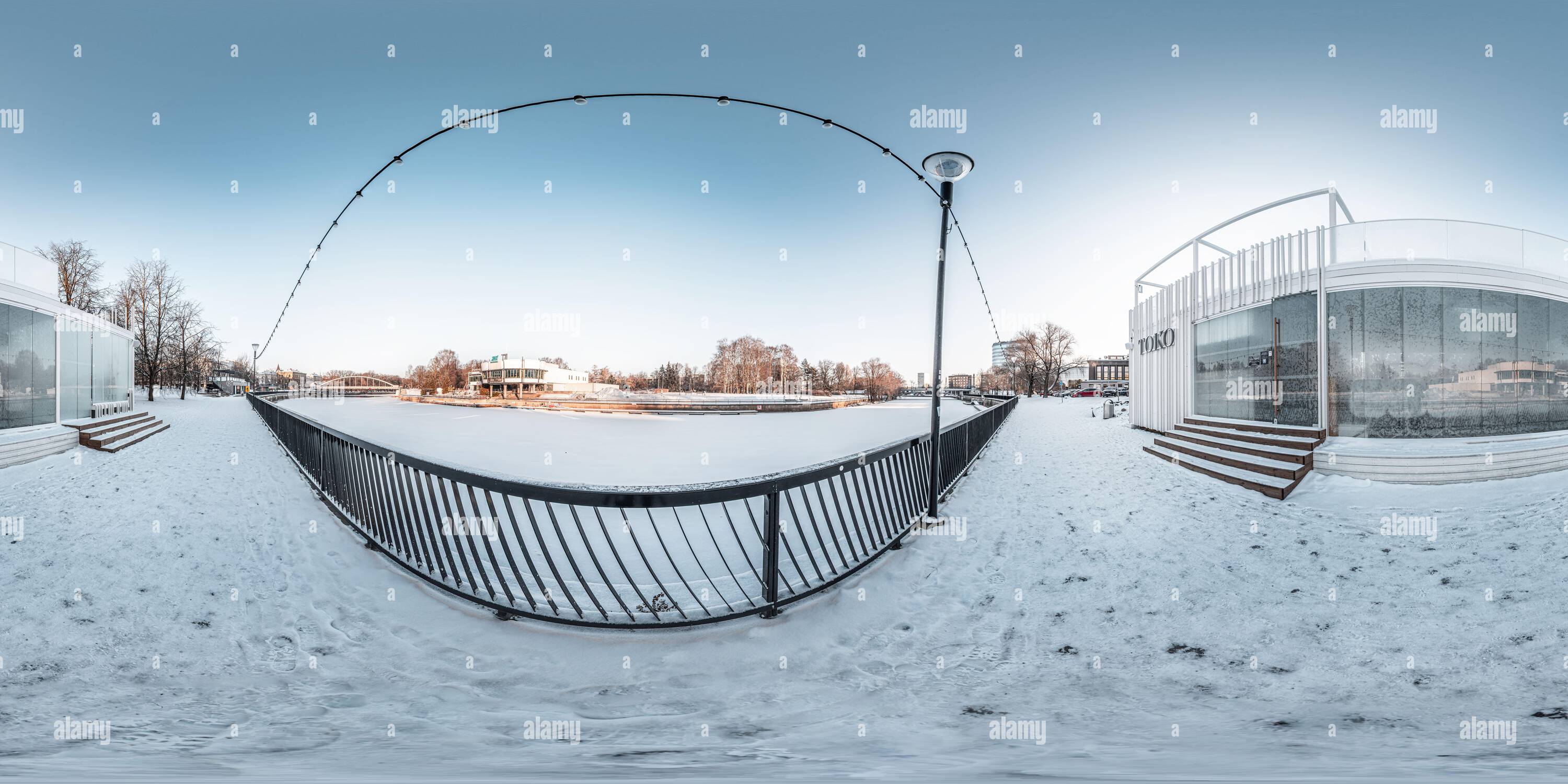 360 degree panoramic view of Winter view next to a frozen river in a small town with lots of snow