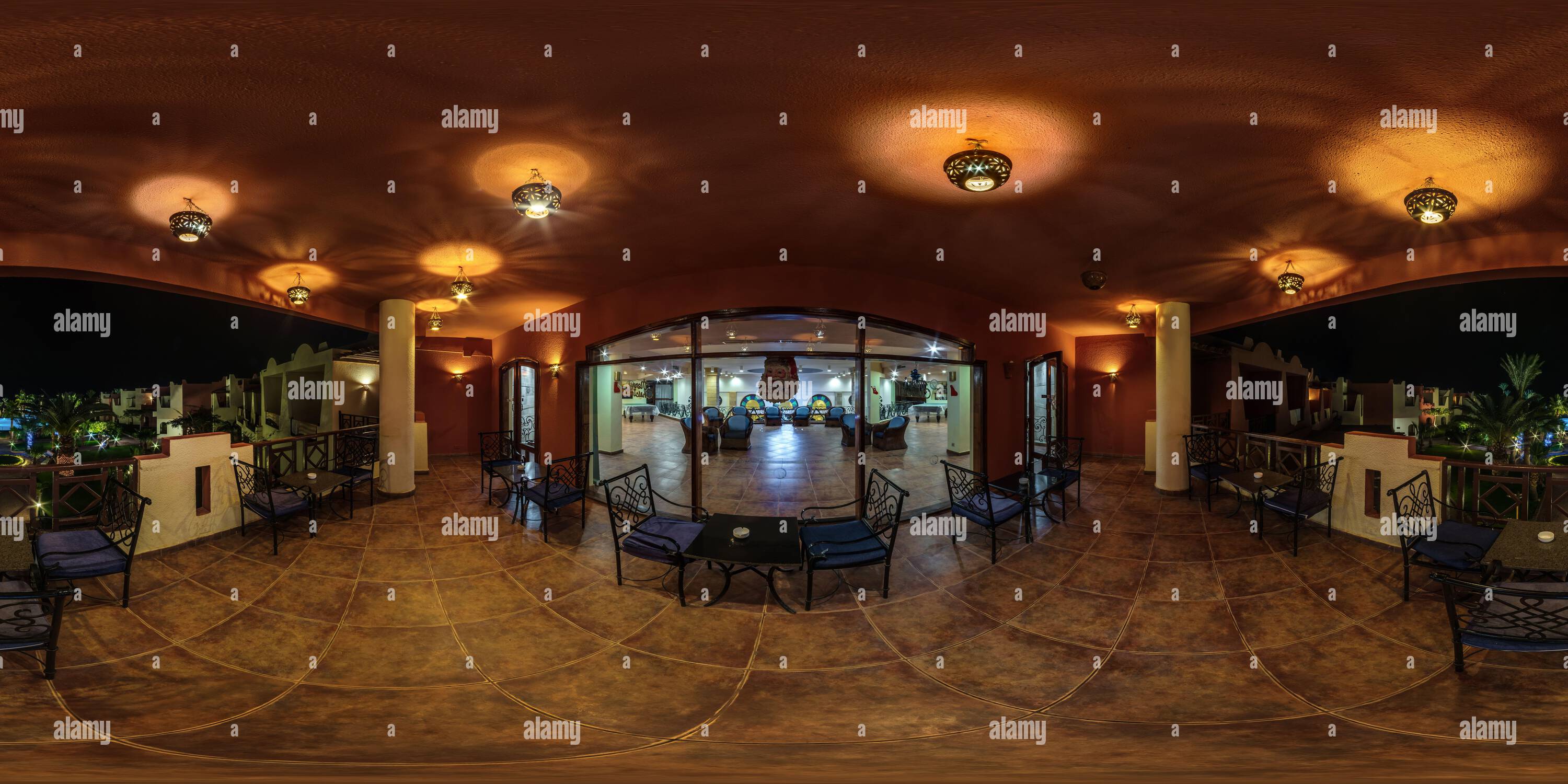 360 degree panoramic view of DAHAB, EGYPT - DECEMBER 2021: full seamless spherical hdr night 360 panorama view on second floor of balcony or terrace overlooking palm trees in equi