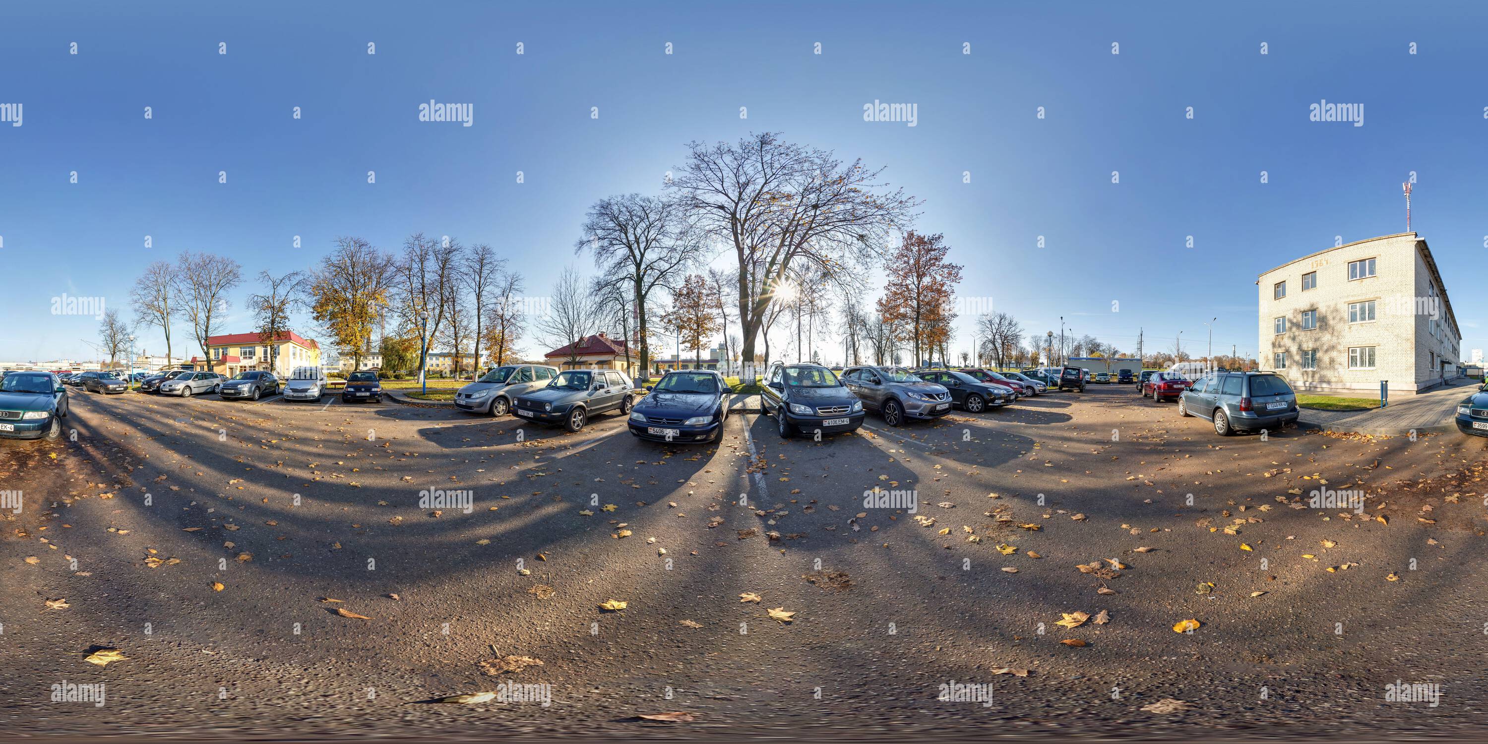 360 degree panoramic view of GRODNO, BELARUS -  NOVEMBER 2021: full seamless hdri panorma 360 angle view on parking with cars near buildings provincial town at autumn sunny day in