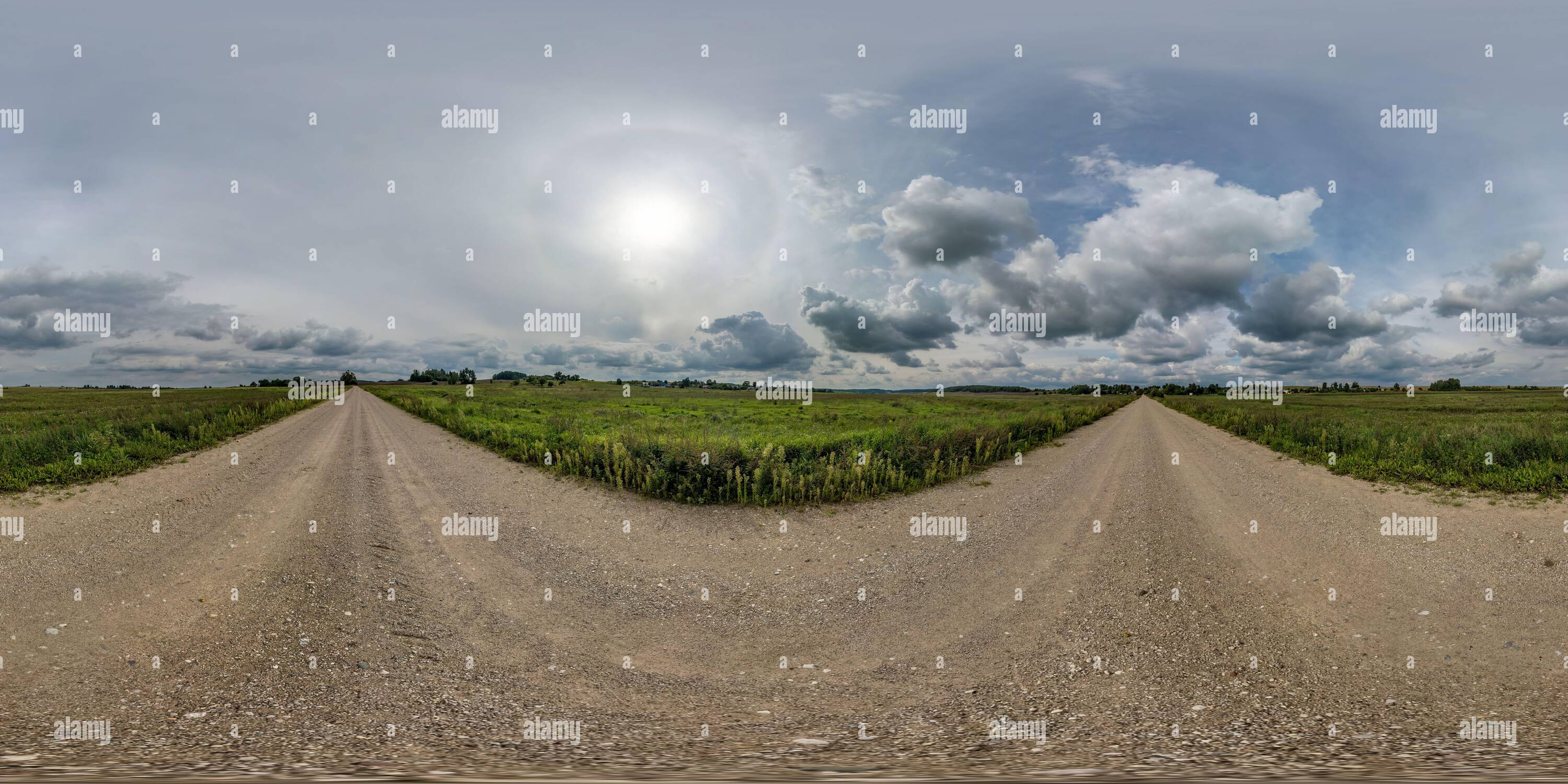 360 degree panoramic view of 360 hdr panorama on no traffic yellow sand gravel road among fields with overcast sky with white clouds and halo in equirectangular spherical projecti