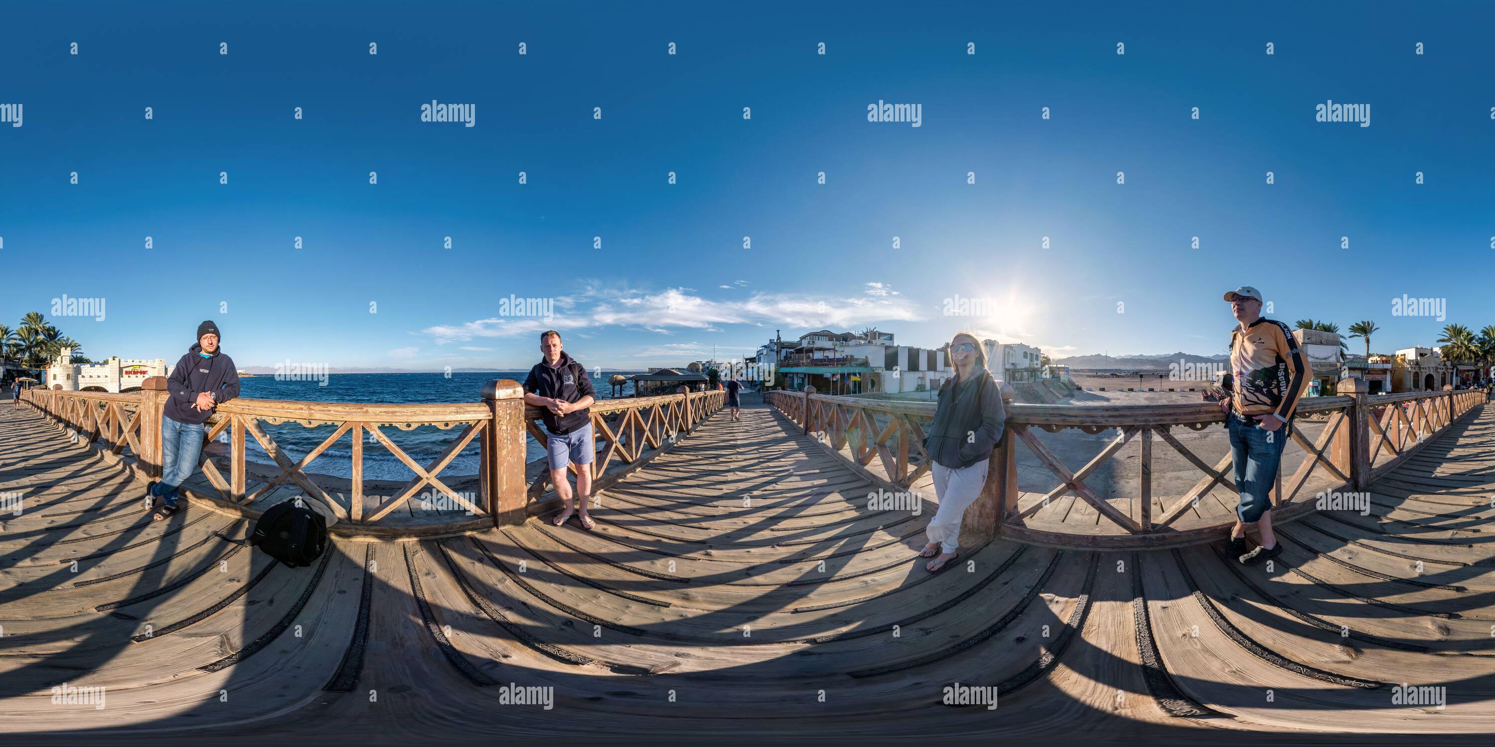 360 degree panoramic view of DAHAB, EGYPT -  DECEMBER 2021: 360 hdr panorama of general photo of four people on the famous bridge by the sea on a pedestrian street in equirectangu