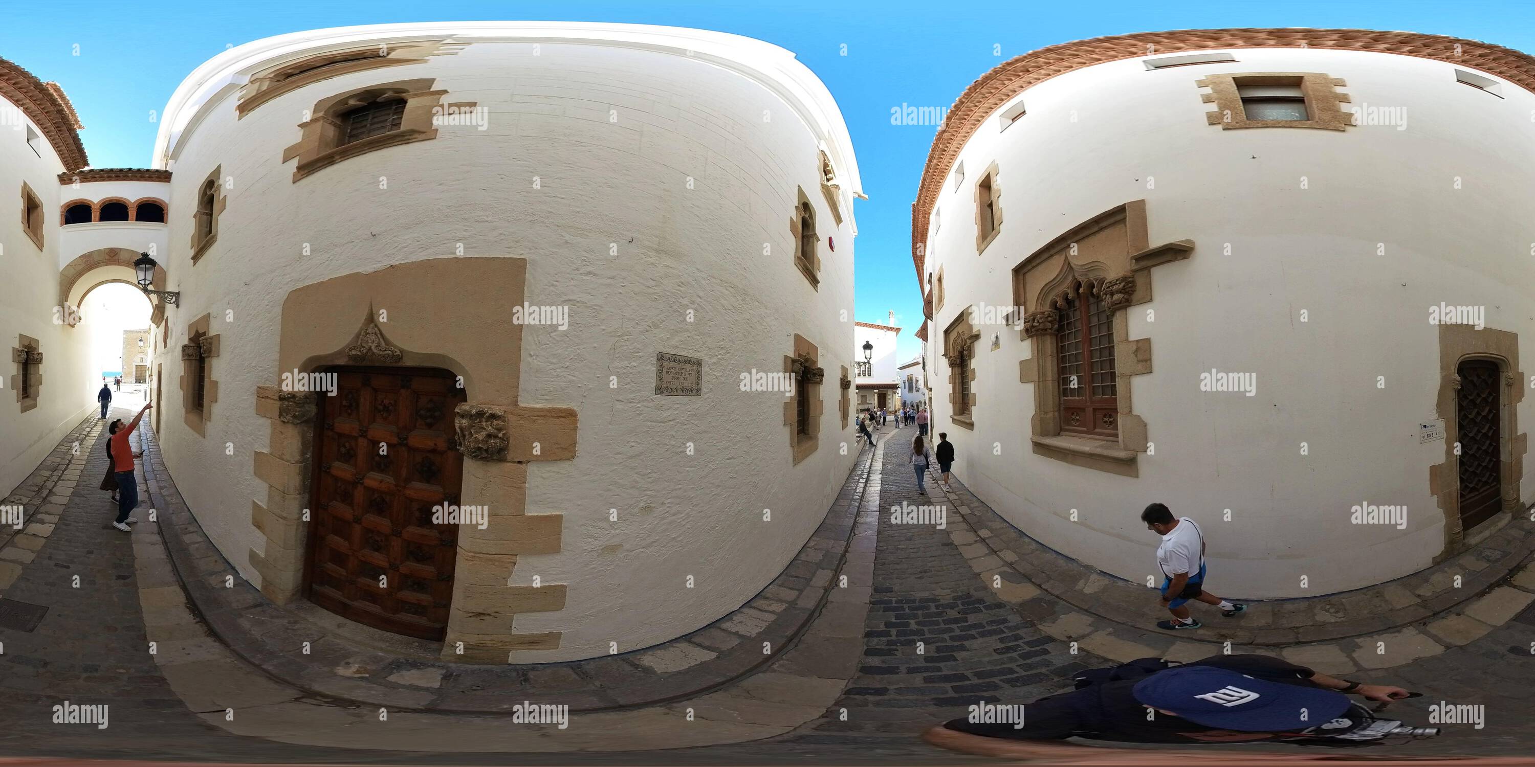 360 degree panoramic view of On a narrow street in Sitges, Spain.  This is the area behind the Church of Sant Bartomeu and Santa Tecla with a beautiful arch and lovely streets