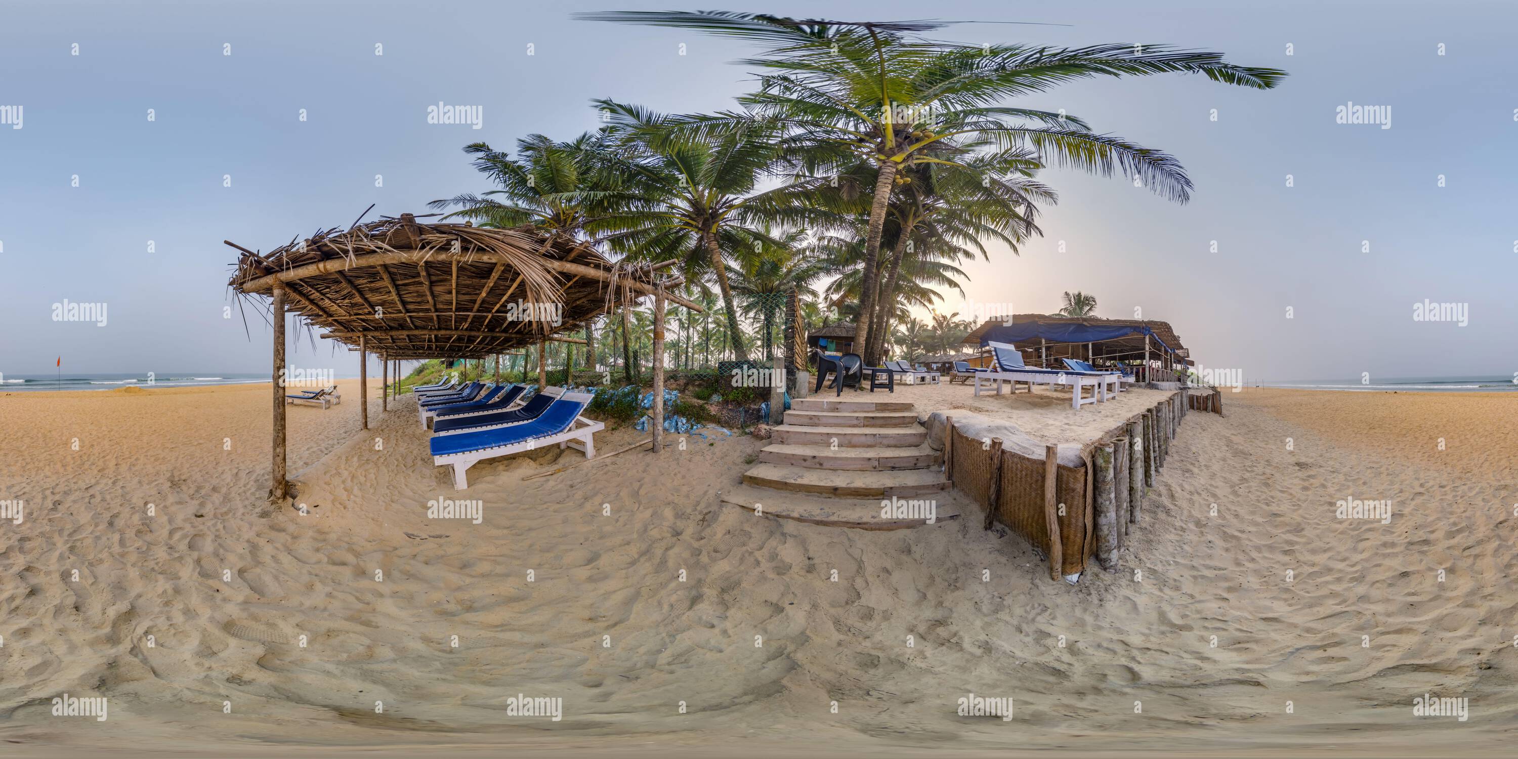 360 degree panoramic view of 360 hdri panorama with coconut trees on ocean coast near tropical shack or open cafe on beach with sunbeds in equirectangular spherical seamless proje