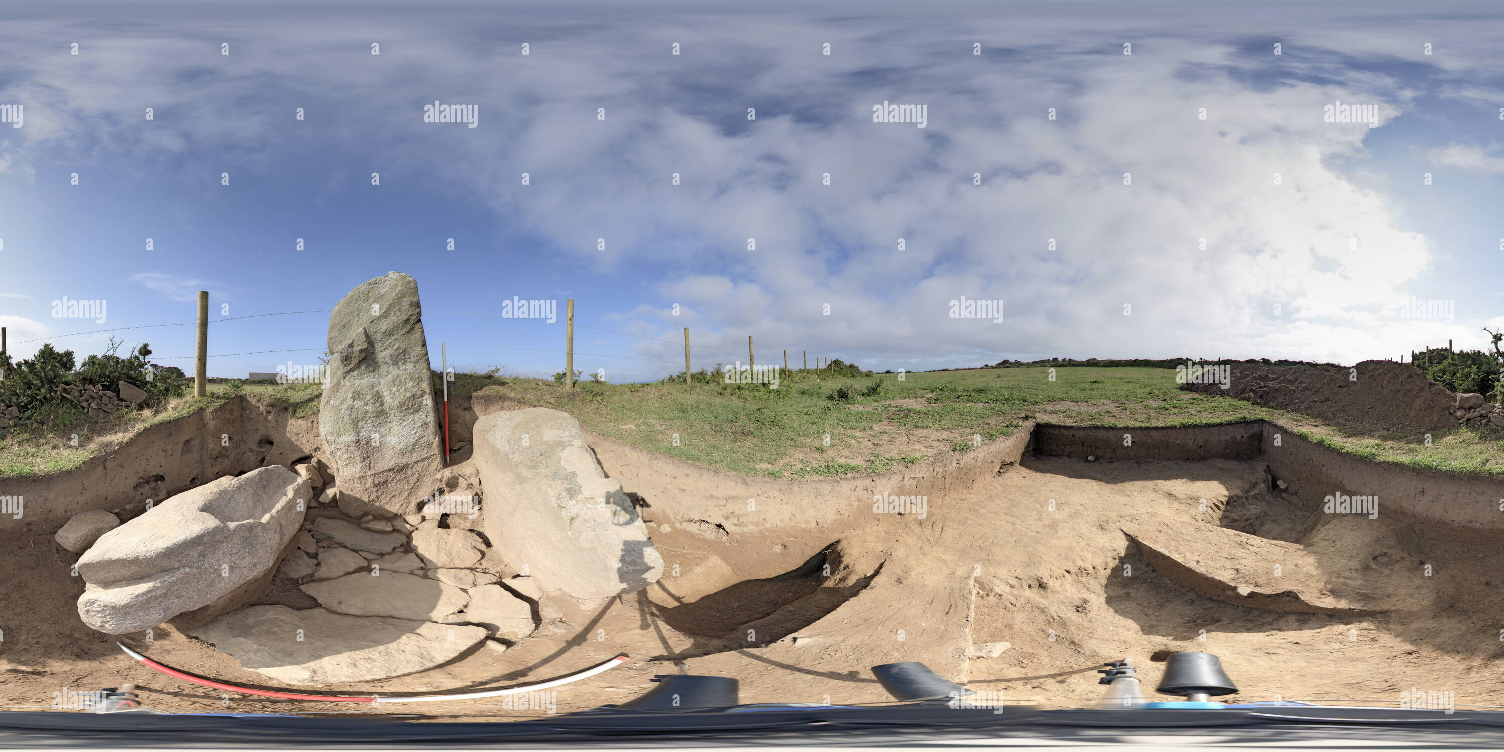 360 degree panoramic view of Excavation at Little Sark LSA15.  These large stones represent bronze Age activity on Little Sark. the Standing stone was erected and then two other large stone formed the 'walls' of a cist burial - note the paving slabs that make up the floor. Although rabbit had heavily disturbed the burial (see the large burrow holes in the earth) and the soil on Little Sark dissolved the bones millennia ago, Beaker period (2500-2200BC) pottery and a stone armguard, used to protect an archer from the bowstring, were found. In front of the cist, a ditch can be seen which produced some Neolithic pottery. For