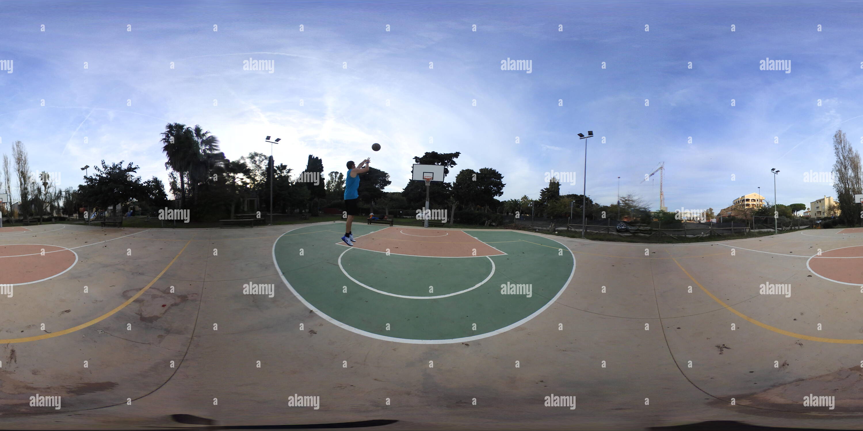 360 degree panoramic view of 360 vr image of a man playing basketball in an outdoor court