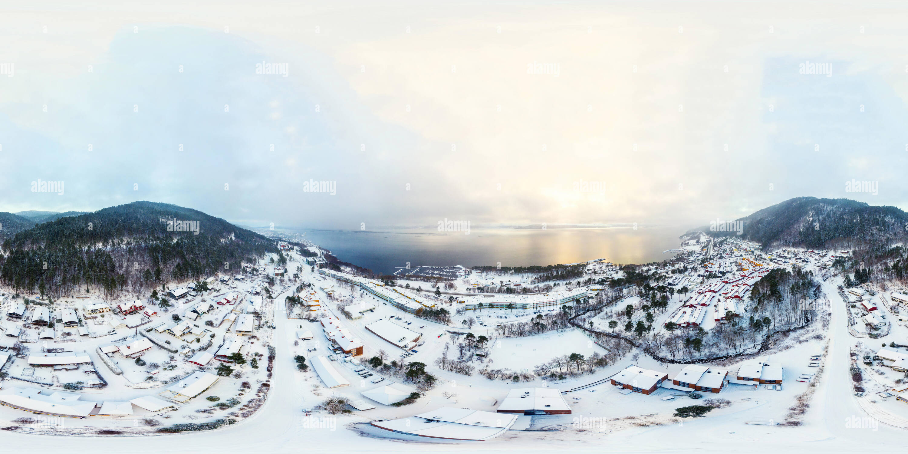 360 degree panoramic view of Molde, Norway. Aerial view of a residential area in Molde, Norway during a cloudy day in winter. The beautiful fjord with mountains covered in snow