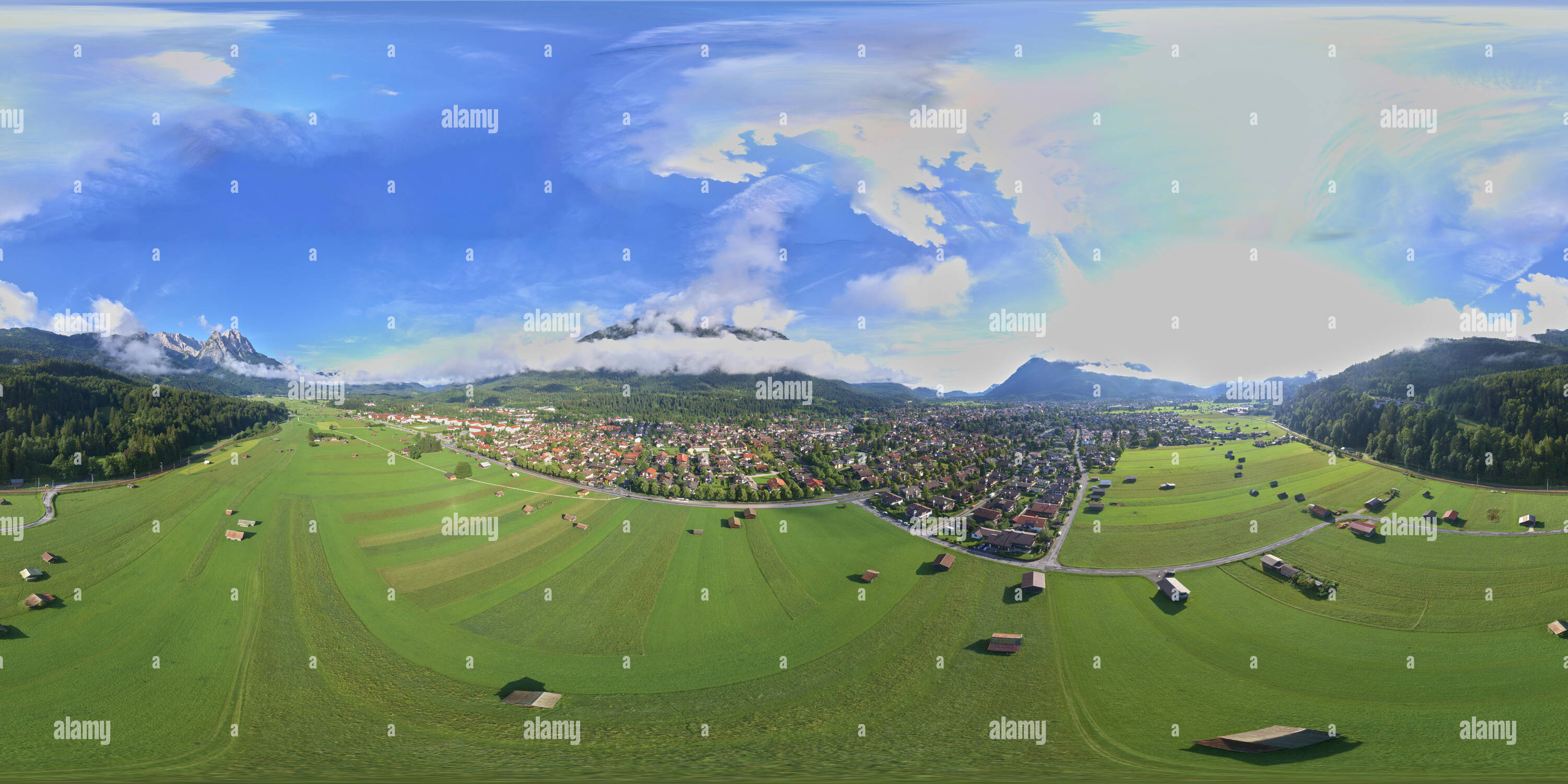 360 degree panoramic view of Mountain meadow near a small town with a holiday cottage settlement with barns and sheds near the Zugspitze massif, Equirectangular 360 degree spheric