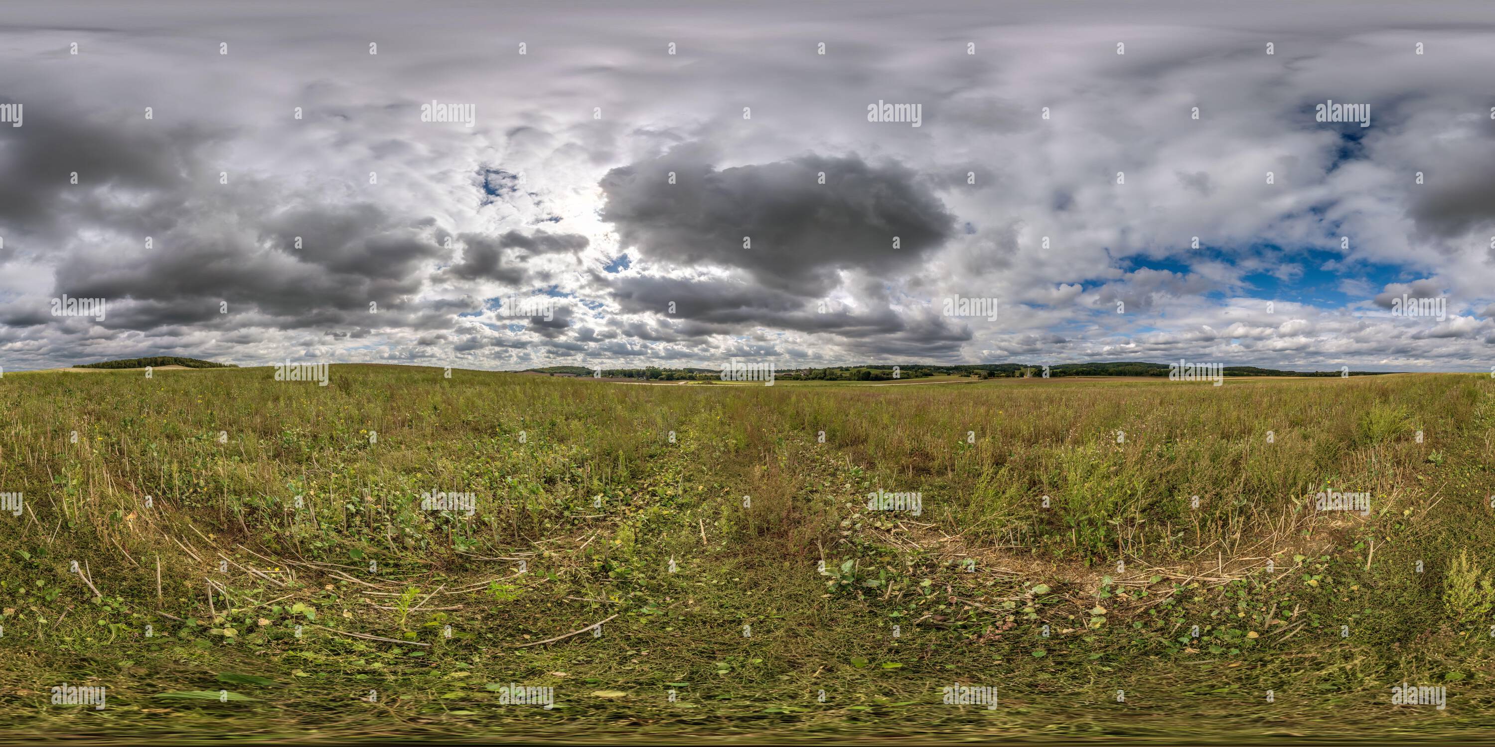 Vue panoramique à 360° de Vue panoramique 360 hdri parfaite entre les champs agricoles avec des nuages dans le ciel couvert en projection sphérique équirectangulaire, prête pour VR AR virtuel