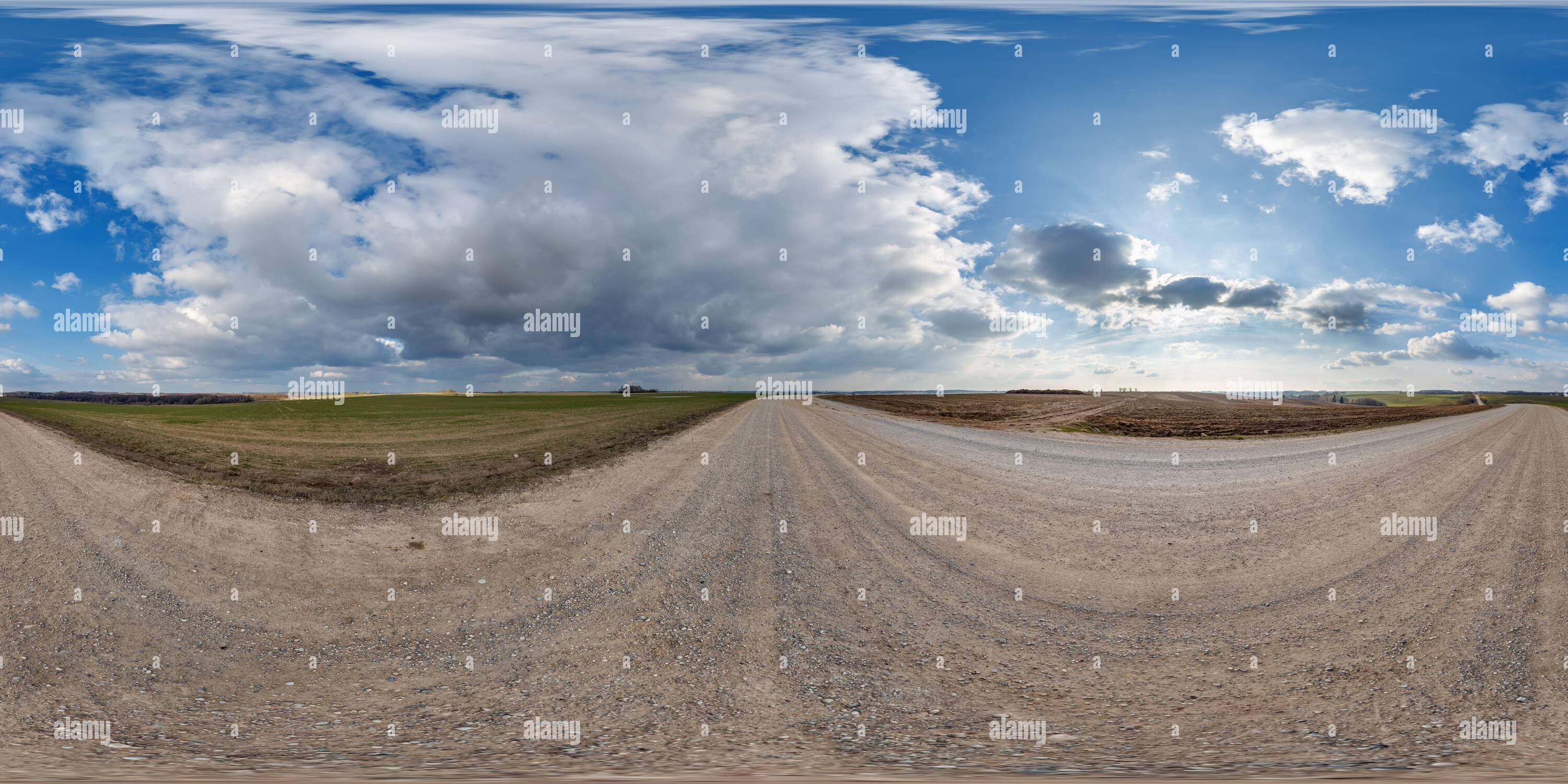 Vue panoramique à 360° de hdri 360 panorama sur la route de gravier parmi les champs dans la soirée de printemps avec des nuages impressionnants en projection sphérique sans soudure équirectangulaire, pour VR AR v