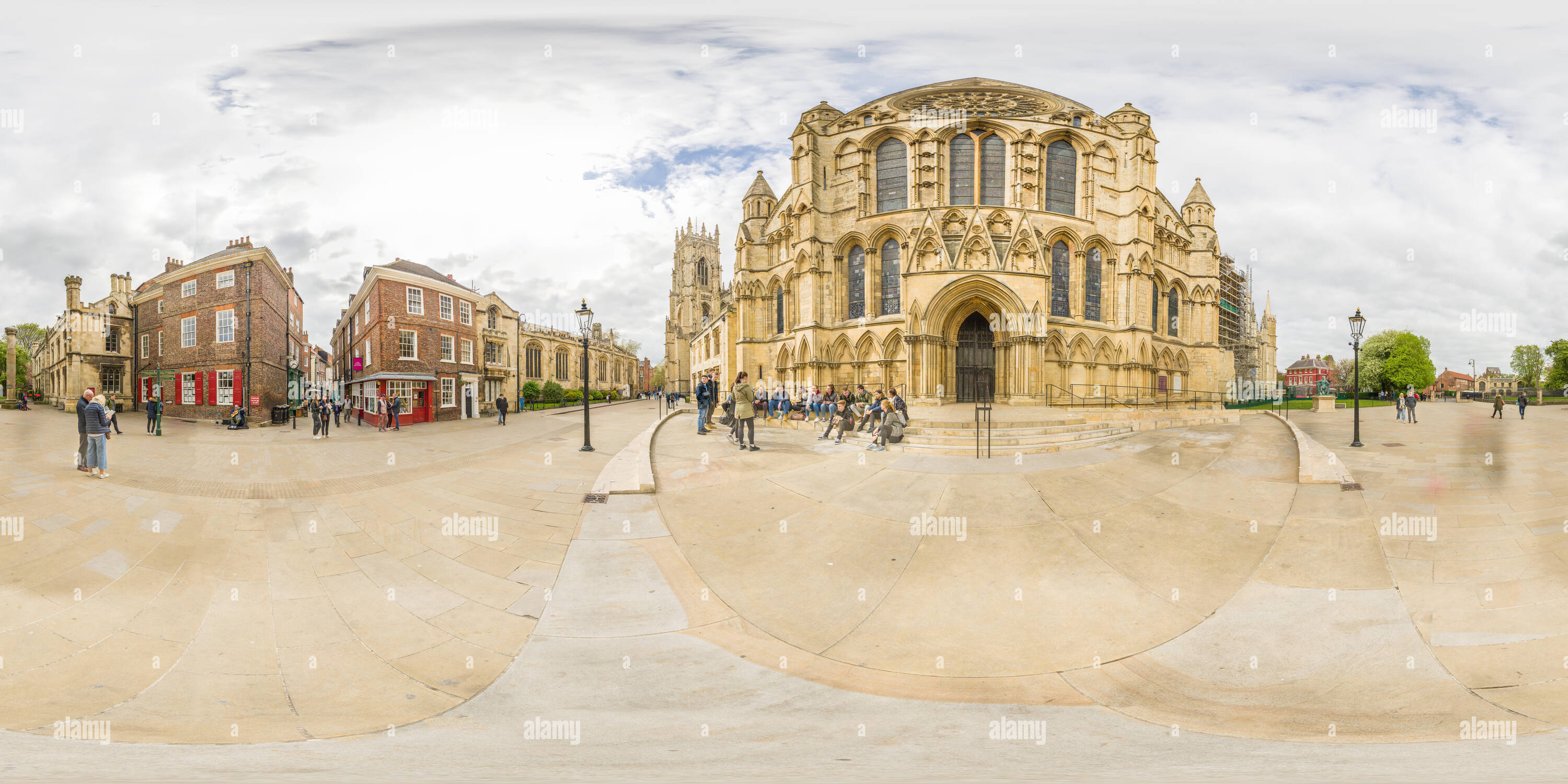 Vue panoramique à 360° de Groupe d'étudiants sur les marches à l'extérieur du sud et entrée à la cathédrale médiévale (minster) à York, en Angleterre, sous un ciel couvert journée de printemps.