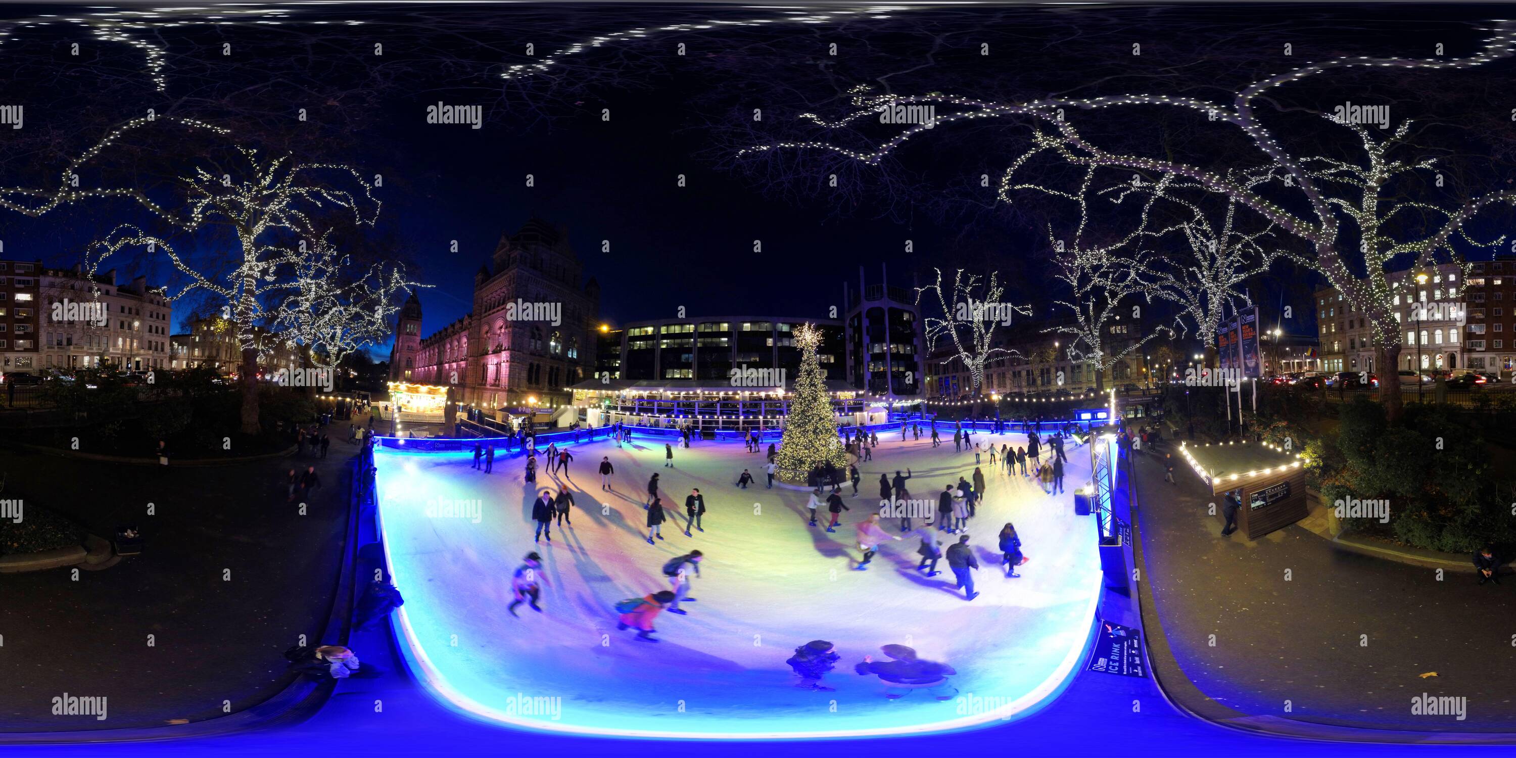 Visualizzazione panoramica a 360 gradi di I pattinatori si divertono prima di Natale mentre pattinano intorno alla pista di pattinaggio al Natural History Museum di Londra. Immagine : Mark Pain / Alamy