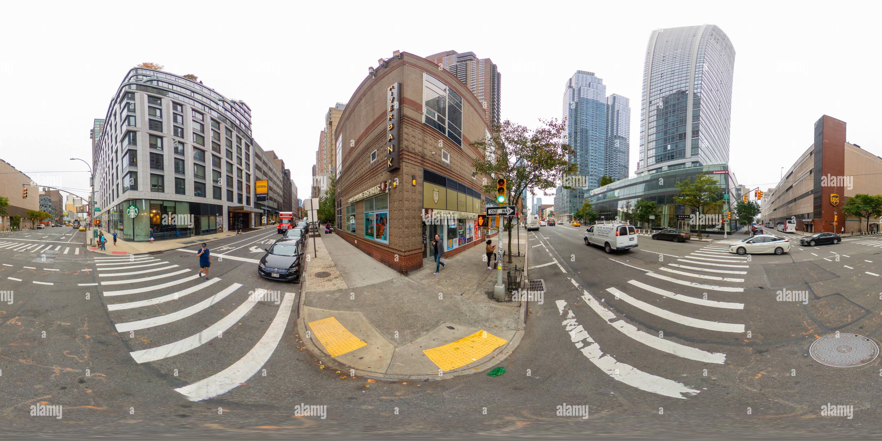 Visualizzazione panoramica a 360 gradi di New York, NY, USA - 27 ottobre 2023: Sponda fluviale Starbucks e Volvo all'incrocio di New York. Foto equirettangolare VR a 360°