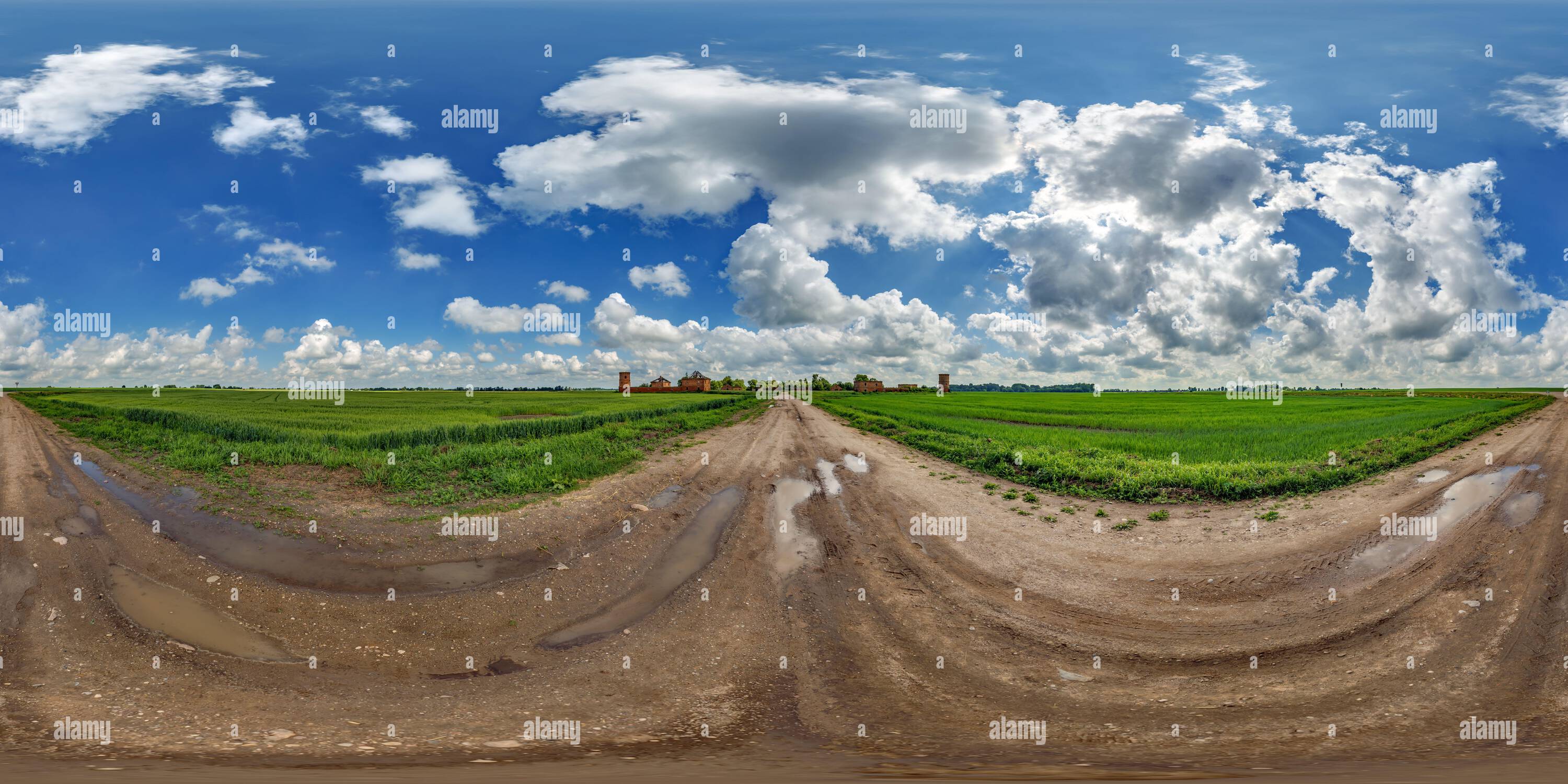 Visualizzazione panoramica a 360 gradi di panorama hdri 360 del cielo blu con nuvole fantastiche su strada ghiaiosa tra campi vicino alle rovine di un castello abbandonato in un pro sferico equirettangolare completamente senza cuciture