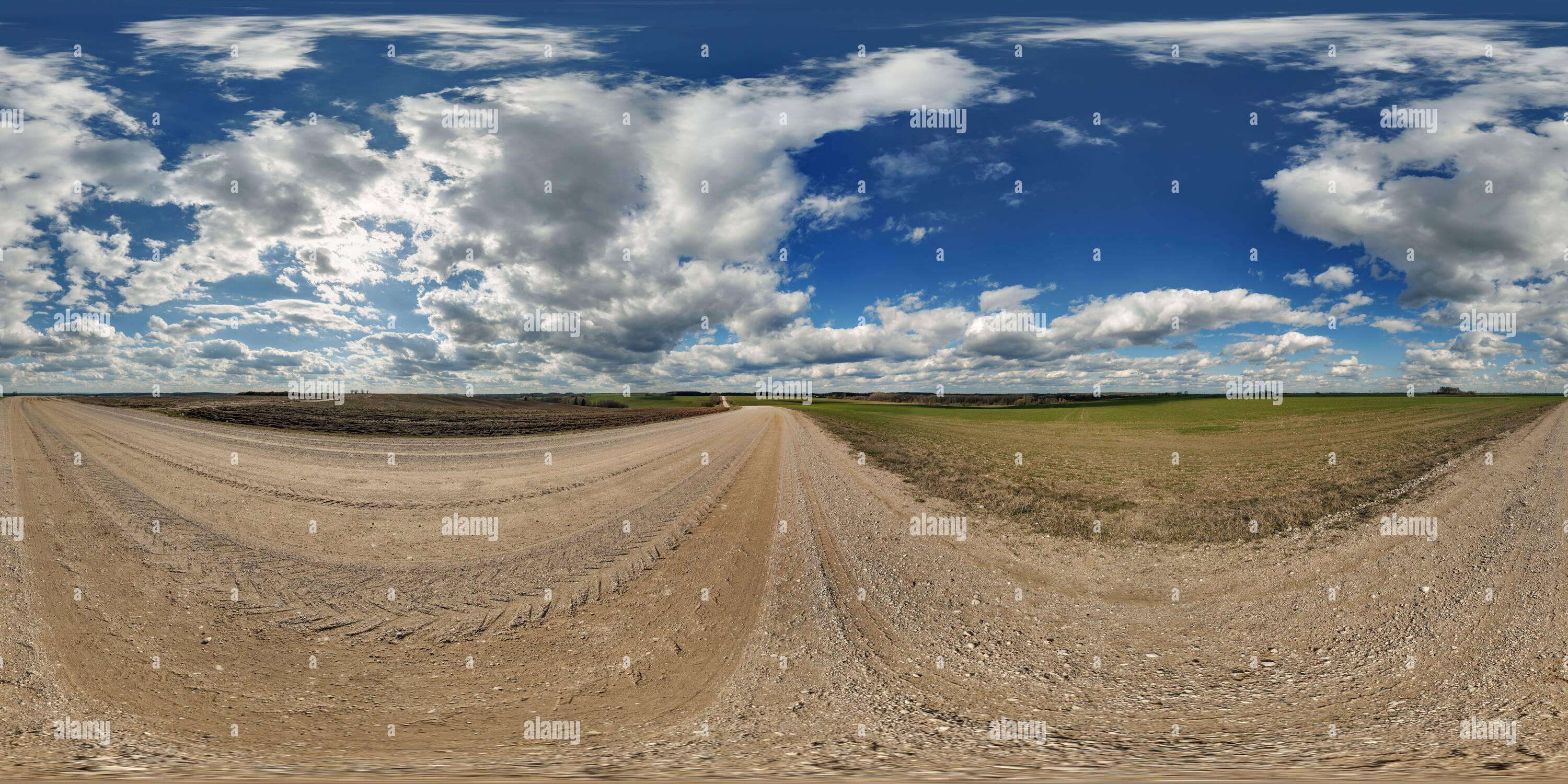 Visualizzazione panoramica a 360 gradi di Panorama hdri 360 del cielo blu con nuvole fantastiche su strada ghiaiosa tra i campi in primavera in proiezione sferica equirettangolare completa e senza cuciture, per VR