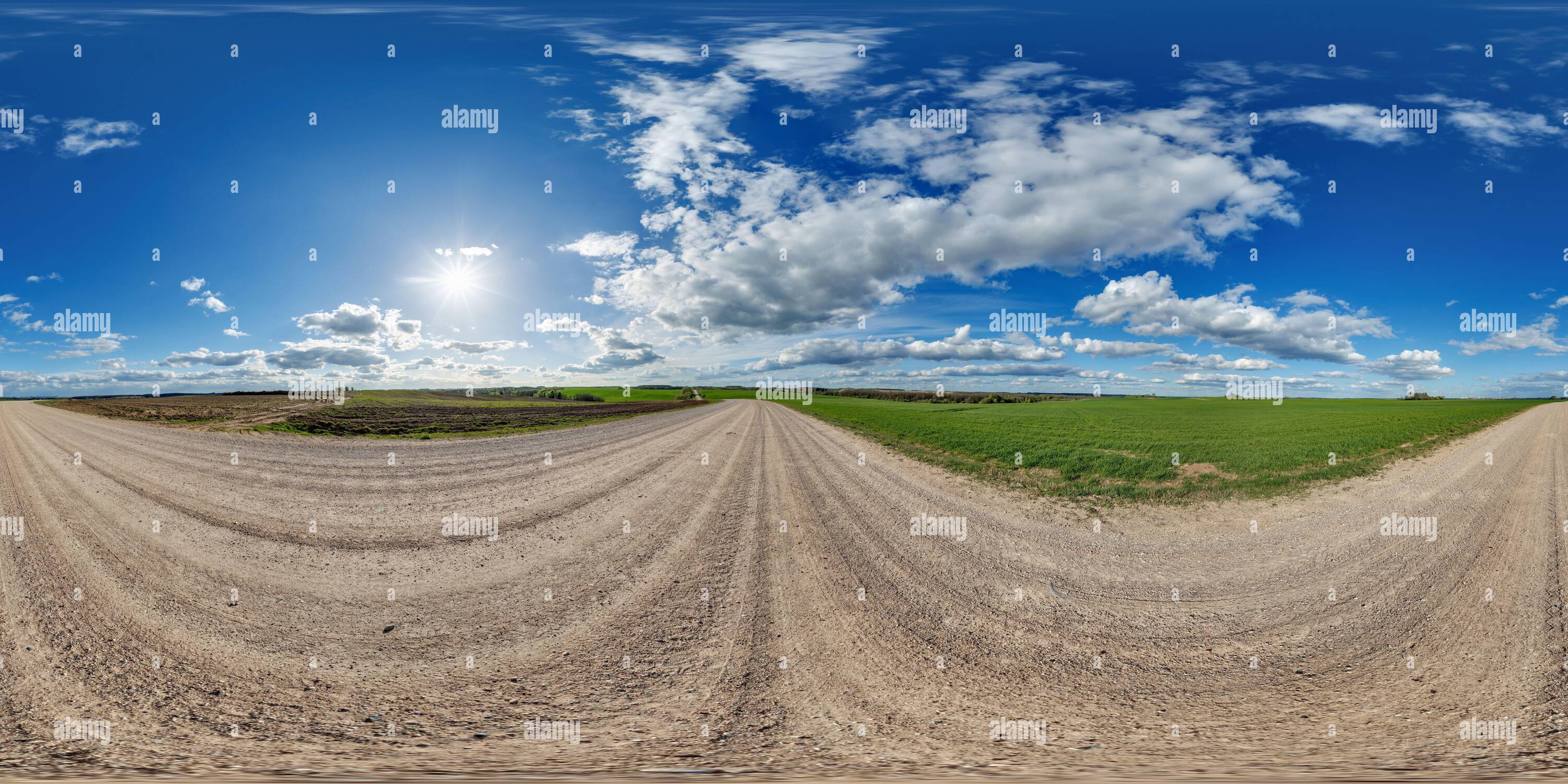 Visualizzazione panoramica a 360 gradi di Panorama hdri 360 del cielo blu con nuvole fantastiche su strada ghiaiosa tra i campi in primavera in proiezione sferica equirettangolare completa e senza cuciture, per VR