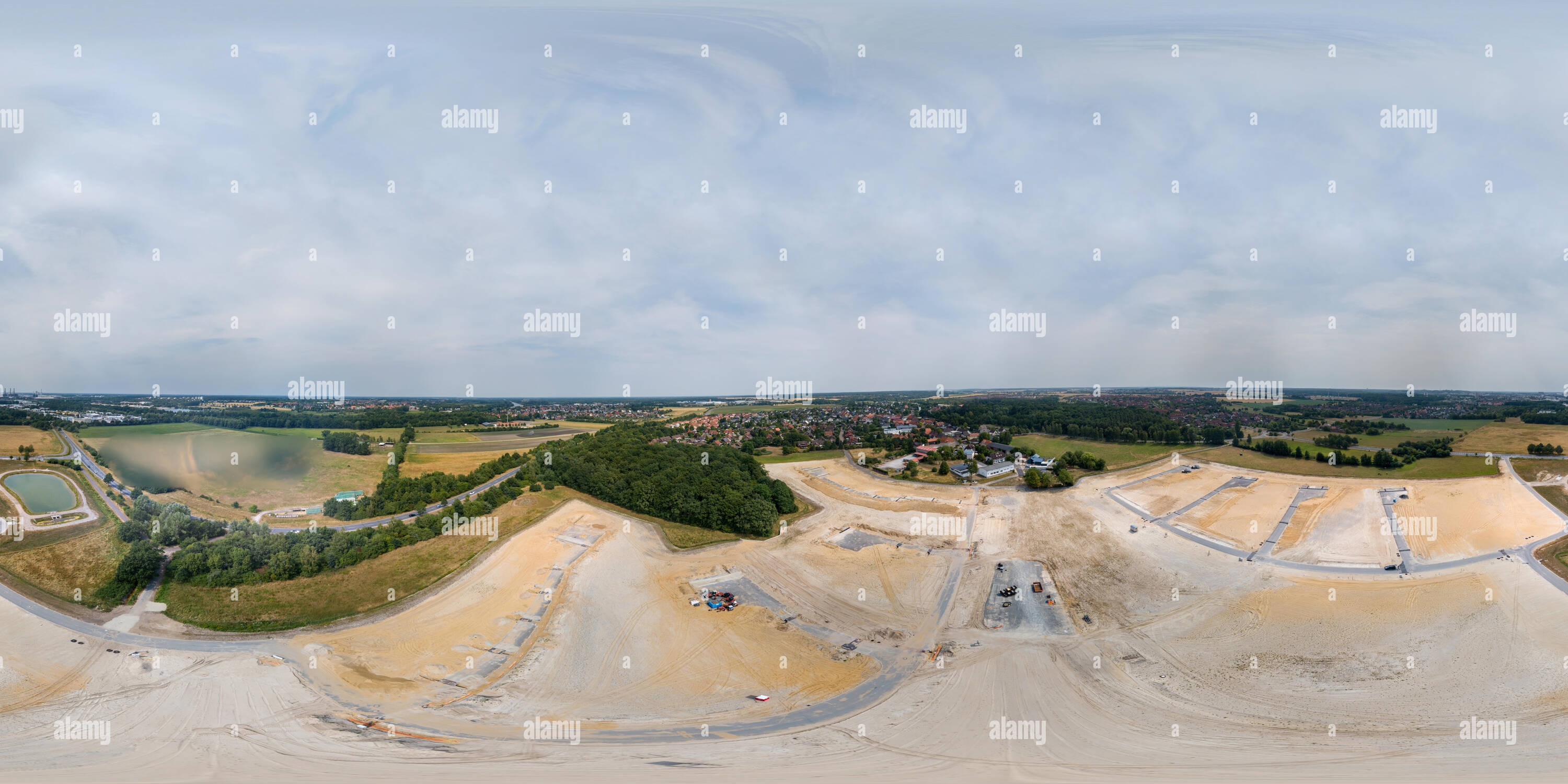 Visualizzazione panoramica a 360 gradi di Panorama a 360 gradi di un bacino di ritenzione dell'acqua piovana a bordo di un nuovo sviluppo accanto a una strada di campagna in Germania, presa in volo con il fuco.