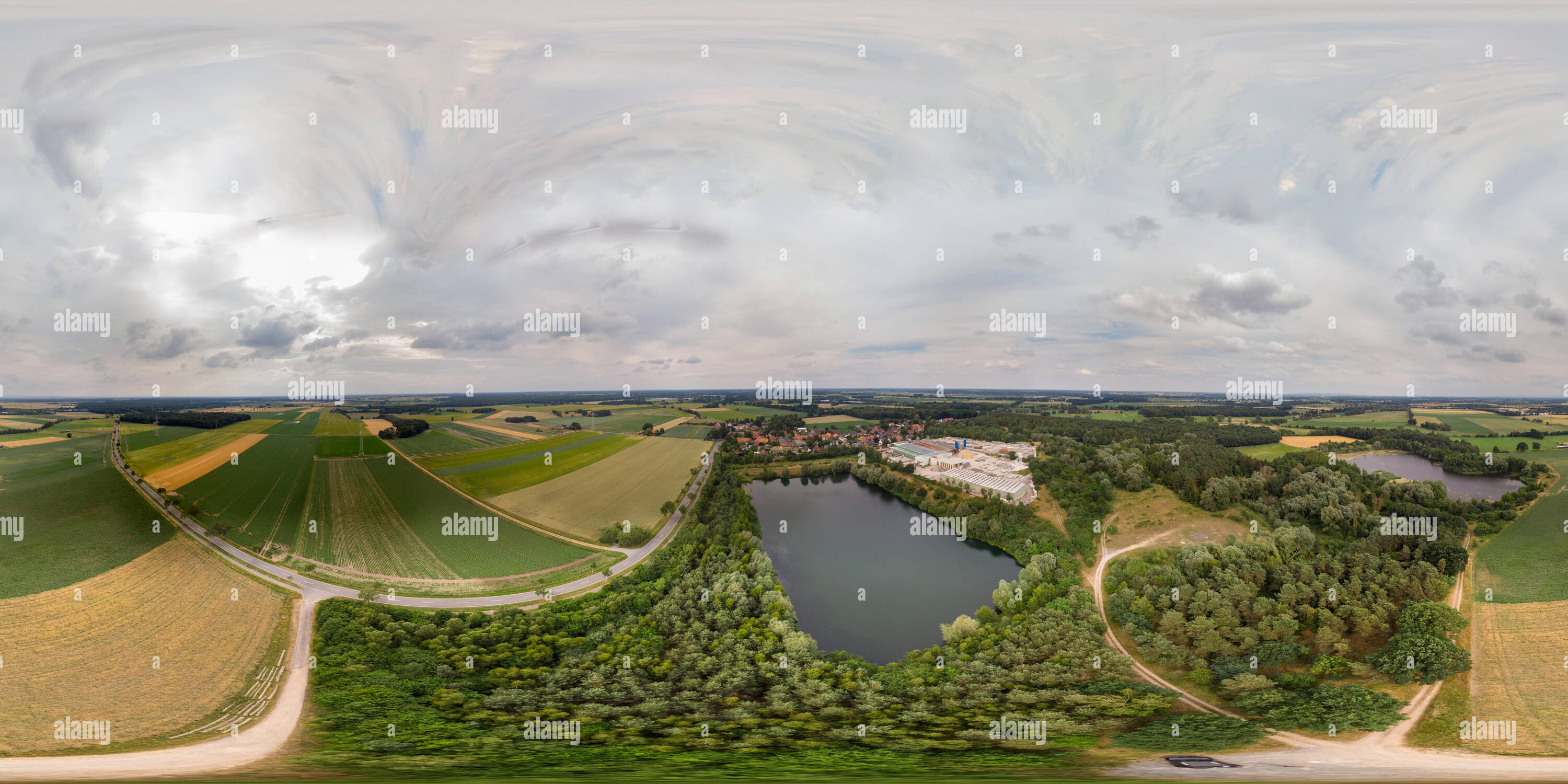 Visualizzazione panoramica a 360 gradi di Il panorama a 360 gradi di una veduta aerea di un piccolo villaggio Tedesco dietro un lago artificiale che è stato creato da sabbia mining per un impianto di calcestruzzo